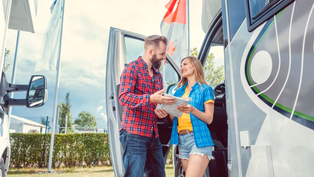 A couple standing inside a Class C motorhome reviewing a floor plan while learning how to choose an RV.